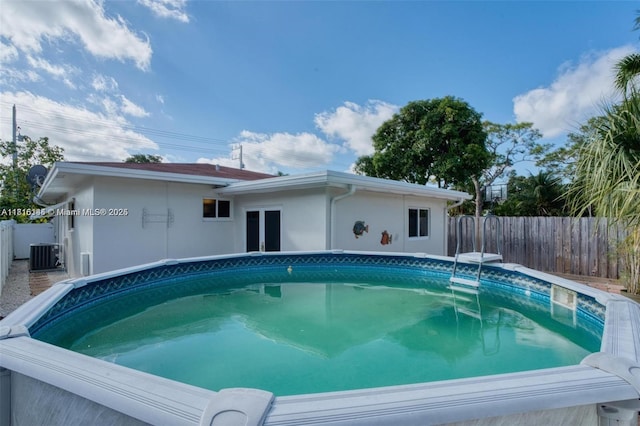 735 NE 38th St, Oakland Park, FL 33334 - view of swimming pool featuring cooling unit, a fenced backyard, and french doors