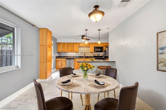 735 NE 38th St, Oakland Park, FL 33334 - dining space featuring light marble finish flooring, baseboards, a ceiling fan, and a textured wall