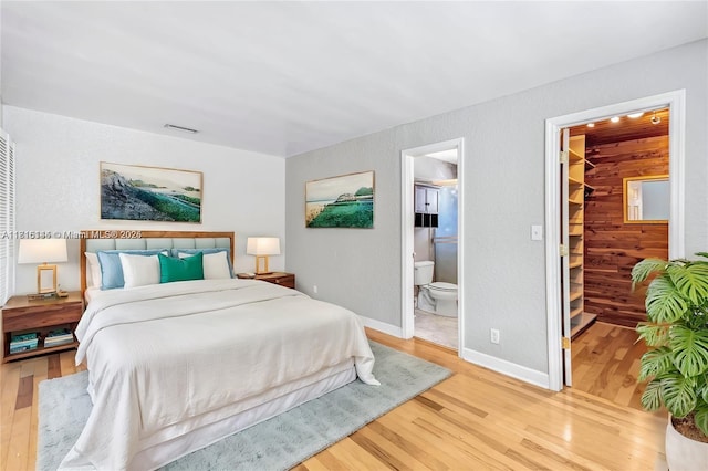 735 NE 38th St, Oakland Park, FL 33334 - bedroom with light wood finished floors, a spacious closet, ensuite bathroom, and baseboards