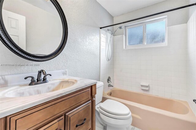 735 NE 38th St, Oakland Park, FL 33334 - full bath with a textured wall, toilet, vanity, and bathing tub / shower combination