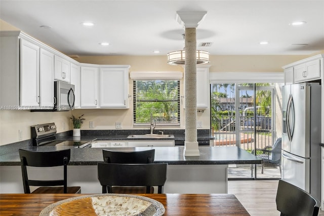 4803 SW Santa Barbara Ct Unit 5, Cape Coral, FL 33914 - kitchen with stainless steel appliances, a breakfast bar area, healthy amount of natural light, white cabinets, and recessed lighting