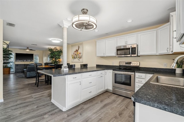 4803 SW Santa Barbara Ct Unit 5, Cape Coral, FL 33914 - kitchen with appliances with stainless steel finishes, a peninsula, white cabinets, open floor plan, and recessed lighting