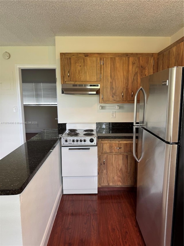 5156 NE 6th Ave Unit 224, Oakland Park, FL 33334 - kitchen with freestanding refrigerator, white electric stove, under cabinet range hood, dark wood-type flooring, and brown cabinets