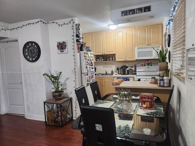110 SE 2nd St Unit 210, Hallandale Beach, FL 33009 - kitchen featuring white appliances, dark wood-style flooring, light countertops, a peninsula, and light brown cabinetry