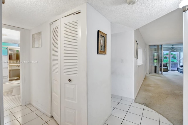 9510 Seagrape Dr Unit 101, Davie, FL 33324 - hallway featuring a textured ceiling, light tile patterned flooring, and baseboards