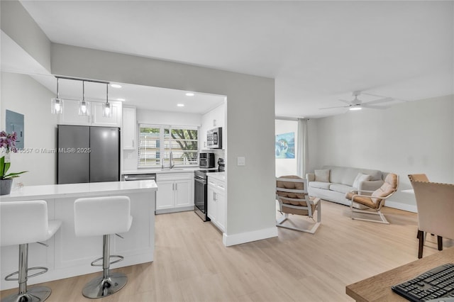9091 Lime Bay Blvd Unit 211, Tamarac, FL 33321 - kitchen with stainless steel appliances, a sink, light wood-style floors, white cabinetry, and recessed lighting