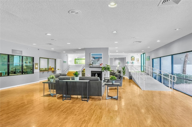 9091 Lime Bay Blvd Unit 211, Tamarac, FL 33321 - living room with wood finished floors, baseboards, a textured ceiling, a fireplace, and recessed lighting