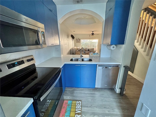 120 SW 109th Ave Unit 3, Sweetwater, FL 33174 - kitchen with stainless steel appliances, blue cabinets, a sink, and wood finished floors