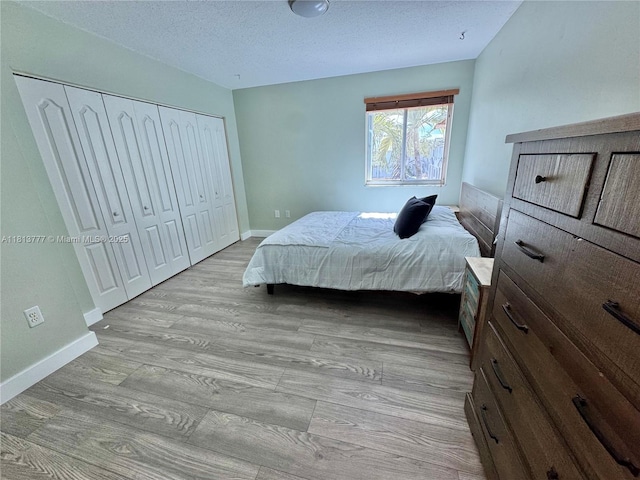 120 SW 109th Ave Unit 3, Sweetwater, FL 33174 - bedroom with light wood-type flooring, baseboards, a closet, and a textured ceiling