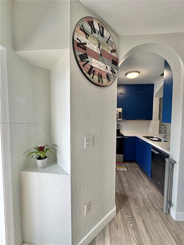 120 SW 109th Ave Unit 3, Sweetwater, FL 33174 - corridor with a textured wall, a sink, light wood-type flooring, arched walkways, and a textured ceiling
