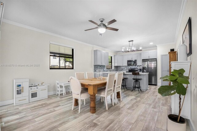 628 SE 37th Pl, Homestead, FL 33033 - dining room featuring a ceiling fan, light wood-style floors, ornamental molding, a chandelier, and baseboards