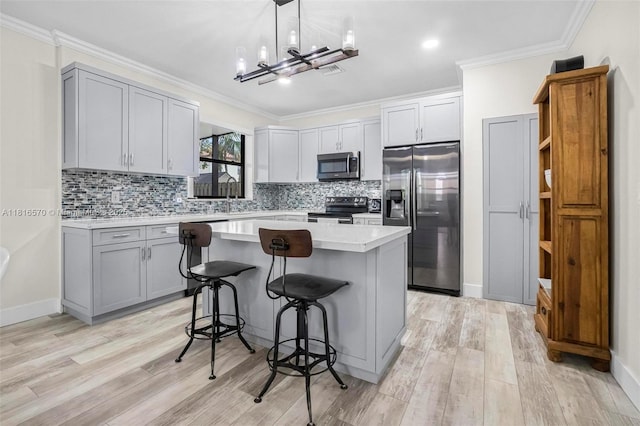 628 SE 37th Pl, Homestead, FL 33033 - kitchen with stainless steel appliances, light countertops, gray cabinets, a center island, and crown molding