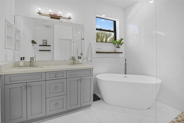 628 SE 37th Pl, Homestead, FL 33033 - bathroom with double vanity, a freestanding bath, a shower, tile patterned floors, and tile walls