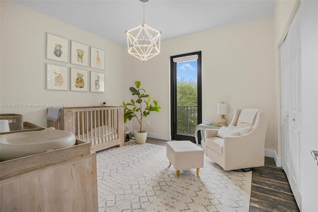 628 SE 37th Pl, Homestead, FL 33033 - bedroom featuring a chandelier, a crib, baseboards, wood finished floors, and a closet