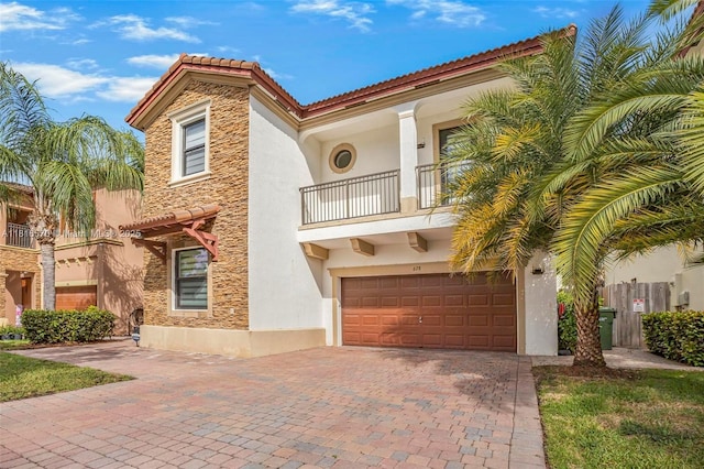 628 SE 37th Pl, Homestead, FL 33033 - mediterranean / spanish-style home featuring a balcony, stucco siding, stone siding, a garage, and decorative driveway