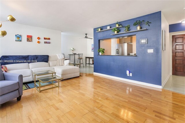 430 Golden Isles Dr Unit 301, Hallandale Beach, FL 33009 - living area with light wood-type flooring, a ceiling fan, and baseboards