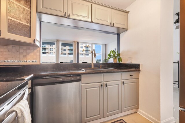 430 Golden Isles Dr Unit 301, Hallandale Beach, FL 33009 - kitchen with stainless steel dishwasher, a sink, tasteful backsplash, glass insert cabinets, and cream cabinets