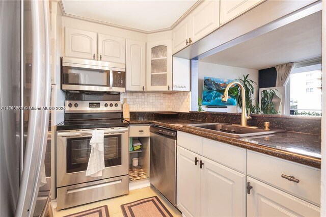 430 Golden Isles Dr Unit 301, Hallandale Beach, FL 33009 - kitchen with stainless steel appliances, a sink, white cabinets, and backsplash