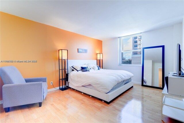 430 Golden Isles Dr Unit 301, Hallandale Beach, FL 33009 - bedroom with light wood-style floors and baseboards