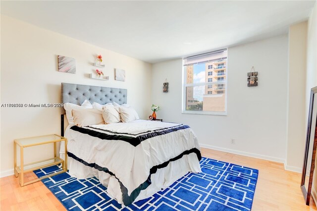 430 Golden Isles Dr Unit 301, Hallandale Beach, FL 33009 - bedroom featuring wood finished floors and baseboards
