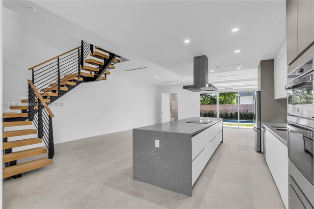 3122 Carter St, Miami, FL 33133 - kitchen featuring modern cabinets, island exhaust hood, a center island, concrete flooring, and recessed lighting