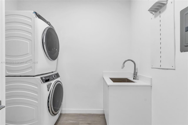 3122 Carter St, Miami, FL 33133 - laundry room with stacked washing machine and dryer, baseboards, and light wood-style floors