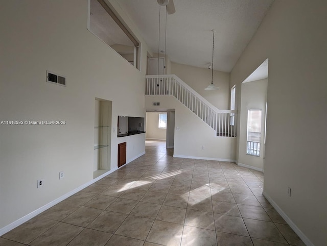 15201 Glenmoor Dr Unit 15201, West Palm Beach, FL 33409 - unfurnished living room with plenty of natural light, stairway, a high ceiling, a ceiling fan, and baseboards