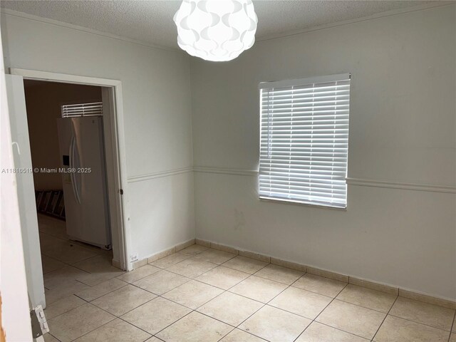 661 E 44th St, Hialeah, FL 33013 - spare room with light tile patterned flooring, a textured ceiling, and a chandelier