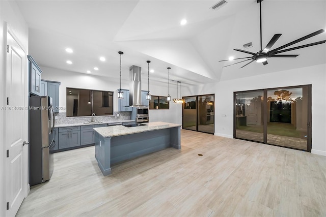 4308 3rd St SW, Lehigh Acres, FL 33976 - kitchen featuring freestanding refrigerator, a sink, tasteful backsplash, light stone counters, and a kitchen island