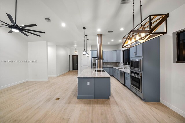 4308 3rd St SW, Lehigh Acres, FL 33976 - kitchen with stainless steel appliances, a center island, island exhaust hood, a sink, and light stone countertops