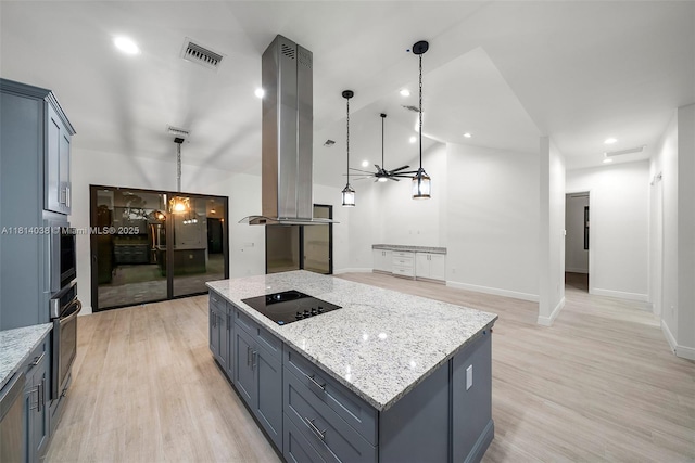 4308 3rd St SW, Lehigh Acres, FL 33976 - kitchen with black electric stovetop, oven, light stone counters, a center island, and light wood-style flooring