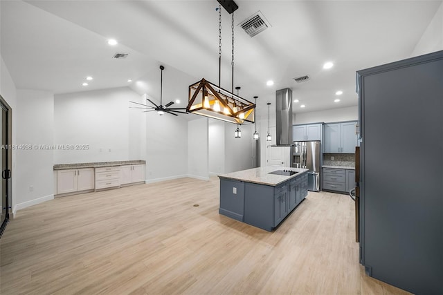 4308 3rd St SW, Lehigh Acres, FL 33976 - kitchen featuring stainless steel fridge with ice dispenser, island exhaust hood, an island with sink, light stone counters, and hanging light fixtures