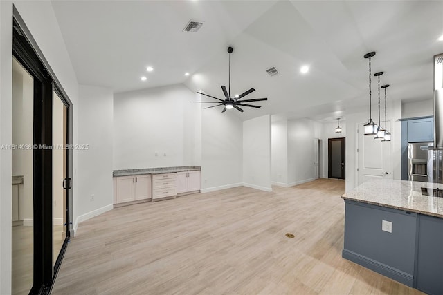 4308 3rd St SW, Lehigh Acres, FL 33976 - kitchen featuring light stone countertops, lofted ceiling, a ceiling fan, pendant lighting, and light wood-type flooring