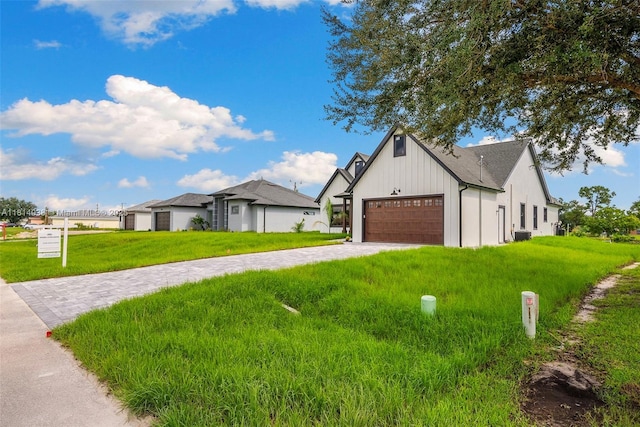 4308 3rd St SW, Lehigh Acres, FL 33976 - view of front of house with a garage, a front yard, decorative driveway, and board and batten siding