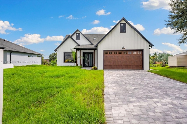 4308 3rd St SW, Lehigh Acres, FL 33976 - view of front of property featuring board and batten siding, a garage, decorative driveway, and a front lawn