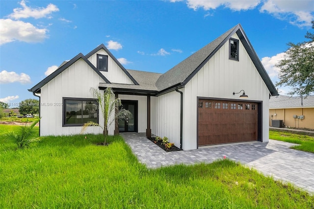 4308 3rd St SW, Lehigh Acres, FL 33976 - modern farmhouse with central AC unit, a garage, board and batten siding, roof with shingles, and decorative driveway