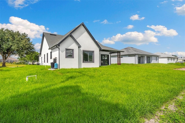4308 3rd St SW, Lehigh Acres, FL 33976 - rear view of house with stucco siding and a yard