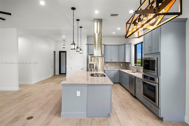 4308 3rd St SW, Lehigh Acres, FL 33976 - kitchen with appliances with stainless steel finishes, gray cabinetry, a sink, a center island, and light stone counters