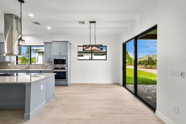 4308 3rd St SW, Lehigh Acres, FL 33976 - kitchen featuring appliances with stainless steel finishes, gray cabinetry, plenty of natural light, light stone countertops, and recessed lighting