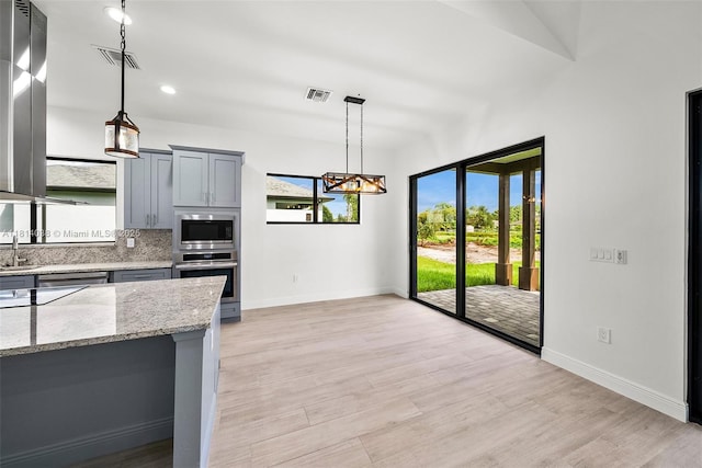 4308 3rd St SW, Lehigh Acres, FL 33976 - kitchen featuring stainless steel appliances, healthy amount of natural light, gray cabinets, and light stone counters