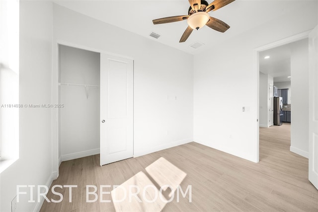 4308 3rd St SW, Lehigh Acres, FL 33976 - unfurnished bedroom featuring freestanding refrigerator, light wood-style floors, a closet, baseboards, and ceiling fan