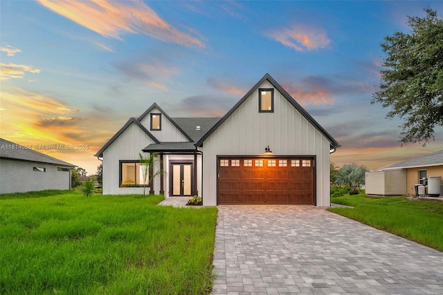 4308 3rd St SW, Lehigh Acres, FL 33976 - modern farmhouse style home featuring an attached garage, a lawn, decorative driveway, and board and batten siding