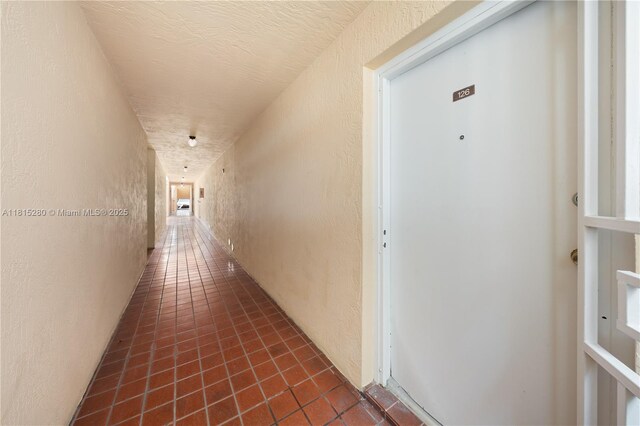 995 SW 84th Ave Unit 126, Miami, FL 33144 - hallway with a textured wall and dark tile patterned floors