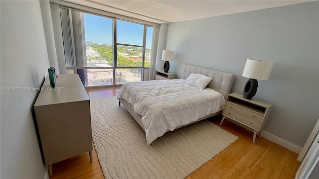 900 Bay Dr Unit 727-725, Miami Beach, FL 33141 - bedroom featuring light wood finished floors, baseboards, and a textured ceiling