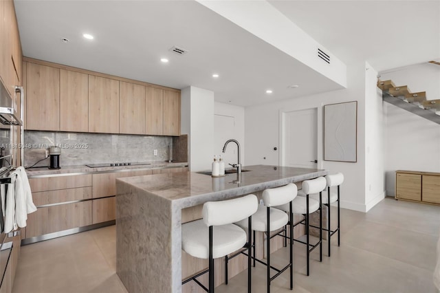 92 SW 3rd St Unit 5204, Miami, FL 33130 - kitchen with light brown cabinets, a sink, modern cabinets, light stone countertops, and backsplash