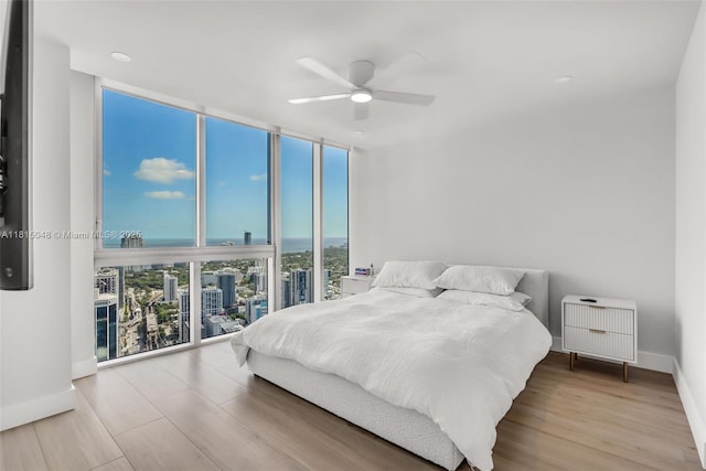 92 SW 3rd St Unit 5204, Miami, FL 33130 - bedroom featuring expansive windows, a view of city, wood finished floors, baseboards, and a ceiling fan