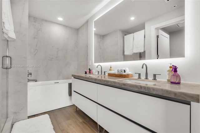 92 SW 3rd St Unit 5204, Miami, FL 33130 - bathroom with double vanity, a bath, wood finished floors, recessed lighting, and a marble finish shower