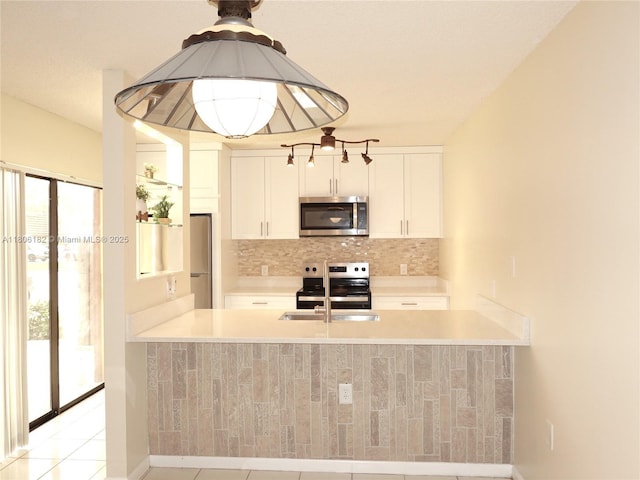 4226 42nd Way, West Palm Beach, FL 33407 - kitchen with stainless steel appliances, a peninsula, decorative backsplash, and light countertops