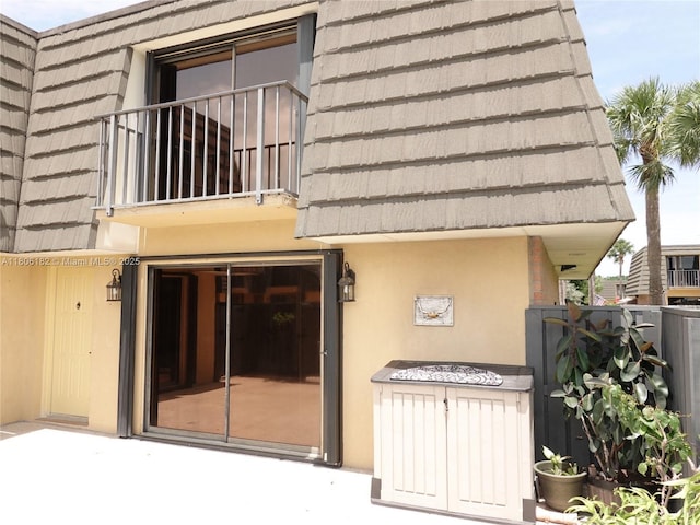 4226 42nd Way, West Palm Beach, FL 33407 - back of property with stucco siding, a balcony, mansard roof, and a patio area