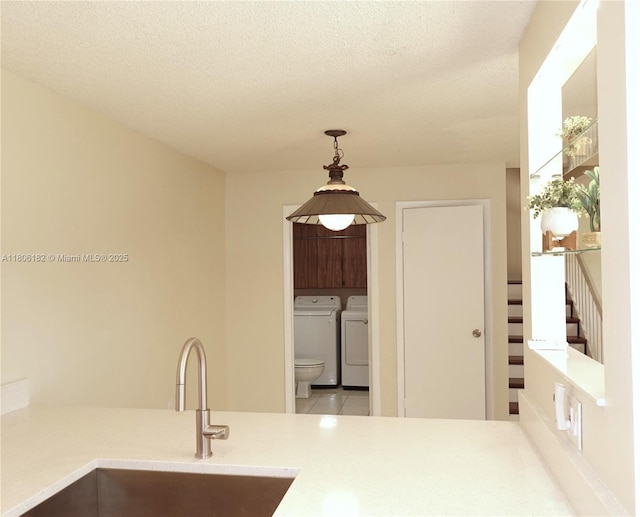 4226 42nd Way, West Palm Beach, FL 33407 - kitchen with a sink, washer and clothes dryer, decorative light fixtures, light countertops, and a textured ceiling